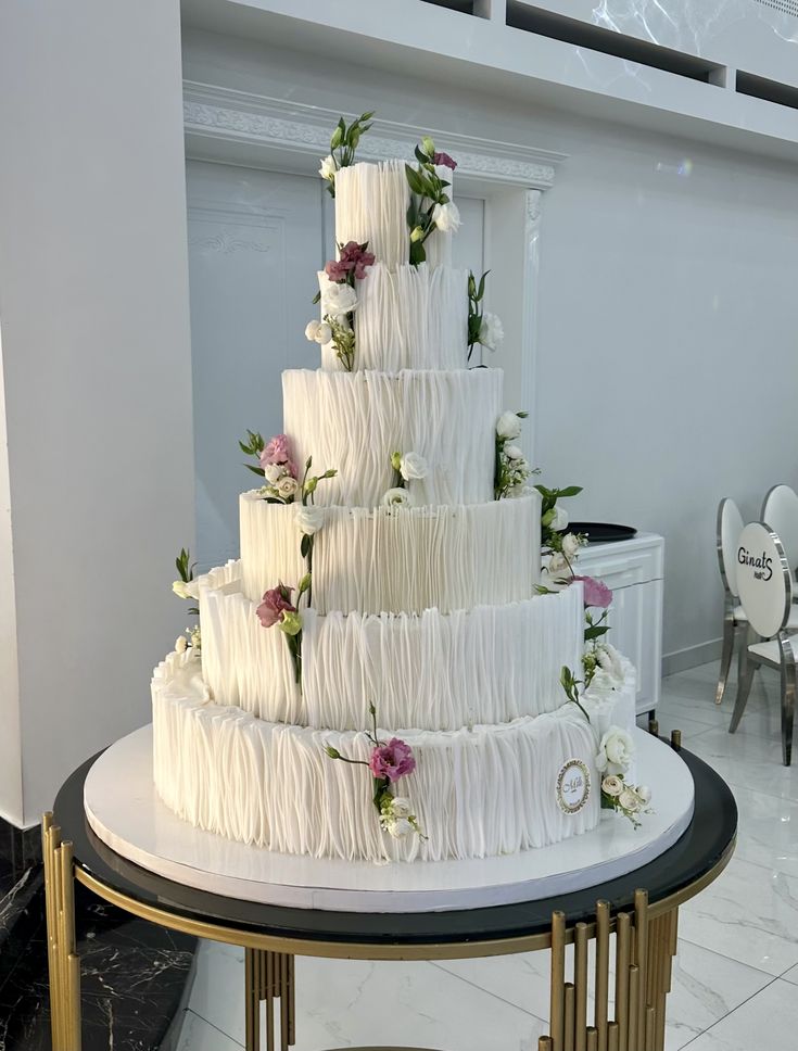 Torta nuziale elegante a sei piani con decorazioni di rose fresche rosa e bianche